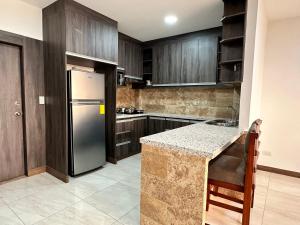 曼塔Katamar的厨房配有木制橱柜和不锈钢冰箱。