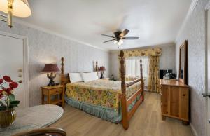 卡梅尔卡梅尔旅馆及套房的一间卧室配有一张床和吊扇