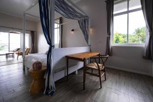 Wok TumBaan Jai Dee Beach Front Hotel的卧室配有床、桌子和窗户。
