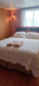 瓦尔迪维亚Apartamentos Cadiz -Valdivia的一间卧室设有两张带白色床单的床和窗户。