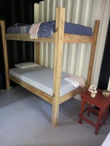 西区TOnat Caribe Hostel的一张带白色床垫和一张桌子的木制双层床