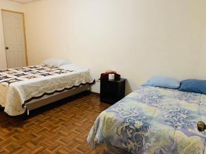 康塞普西翁德阿塔科Sucursal del Cielo的一间卧室设有两张床,铺有木地板