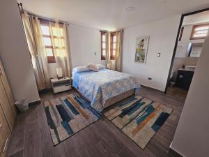 菲兰迪亚Apartamento en Filandia的卧室配有一张床,地板上铺有2个地毯。