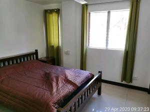 SolangonTropicasa Siquijor Seafront Guest House的一间卧室设有一张大床和一个窗户。