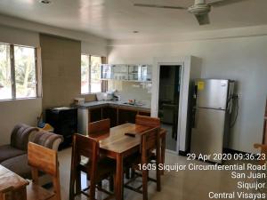 SolangonTropicasa Siquijor Seafront Guest House的厨房配有桌子和冰箱