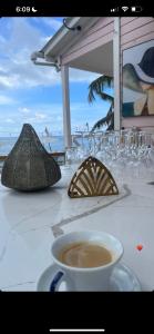Mano JuanCasa rosada beach front的海滩上的桌子,上面放着咖啡和眼镜