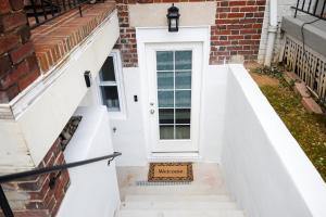 华盛顿Amma's Place的砖屋的白色前门,有楼梯