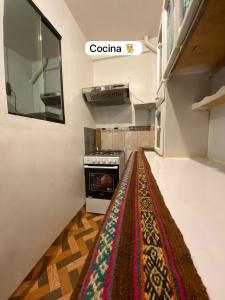 库斯科Casa Katya Cusco的厨房铺有地板上的地毯。