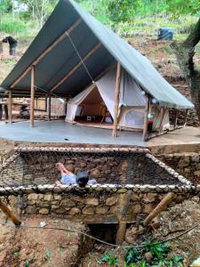 埃拉Ella Retreat Glamping Tent on Hill for Nature Lovers的躺在帐篷前墙上的人