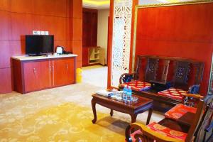 万象Dansavanh Vientiane Hotel的客厅配有桌子和电视