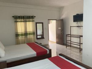 阿努拉德普勒Nugasewana Guest的酒店客房,设有两张床和镜子