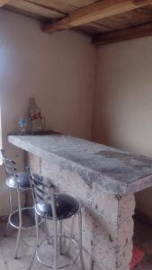 Teul de González OrtegaCabañas Don Jos的石头柜台,配有两把椅子和一张桌子