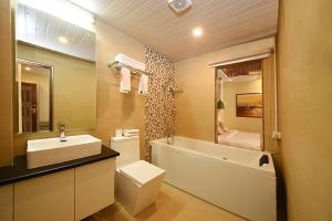 加德满都Woodapple Hotel and Spa的浴室配有盥洗盆、卫生间和浴缸。