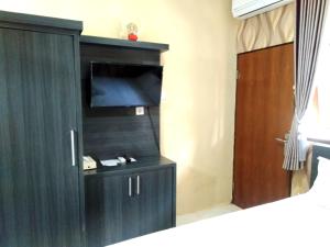 DalungNorth Wing Canggu Resort的一间设有黑色橱柜、电视和门的房间