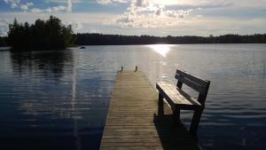 Sysmä特拉勒托尔帕度假屋的坐在湖面上的一个船坞上的长凳