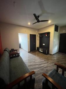 奇克马格尔Shobha Comforts的带沙发和吊扇的客厅