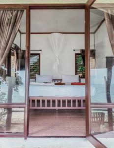 皮皮岛Phi Phi Private Beach Resort的一间玻璃门房内的卧室