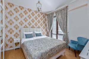 巴库里阿尼HCG Panorama Villa Deluxe Apartment的一间卧室配有一张床和一张蓝色椅子