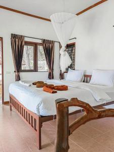 皮皮岛Phi Phi Private Beach Resort的一间卧室配有一张带白色床单的大床