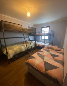 都柏林Dublin Airport Big rooms with bathroom outside room - kitchen only 7 days reservation的一间卧室设有两张双层床和一扇窗户。