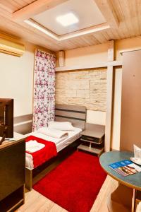 马赫穆迪亚卡萨提奥酒店的小房间,配有床和红色地毯