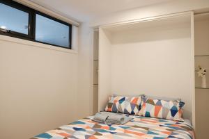 堪培拉CBD Japanese Retreat 2BR 1P Brekky Wifi Netflix的一间卧室设有一张床和一个窗口