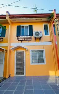 武端市Modern House in Butuan City with 2bedrooms in Camella的黄色的房子,有蓝色的窗户和门