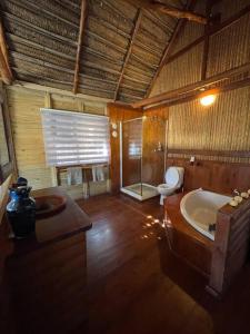 伊尼扬巴内Cheerful 3-bedroom holiday beach cabin.的带浴缸和卫生间的大型浴室