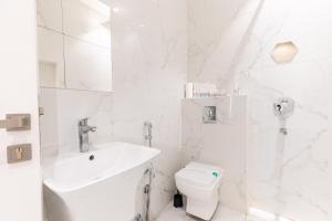 利雅德Amber Al Qairwan的白色的浴室设有水槽和卫生间。
