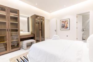 利雅德Amber Hospitality - Al Qairawan的白色的卧室设有一张大床和一间浴室。