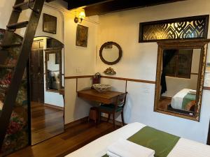 曼谷布鲁斯103号酒店的一间卧室配有一张床、一张桌子和一面镜子