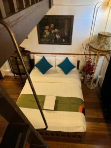 曼谷布鲁斯103号酒店的一间卧室配有一张带蓝色和绿色枕头的床