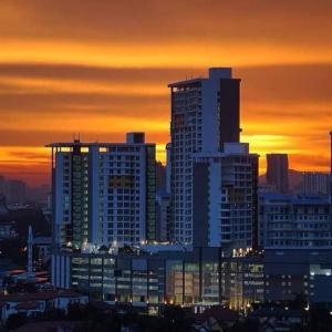 吉隆坡UTM Hotel & Residence的城市天际线,有高耸的建筑,日落