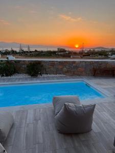 圣安娜纳克索斯White Nadora Naxos Villa的一座蓝色的大型游泳池,背面是日落
