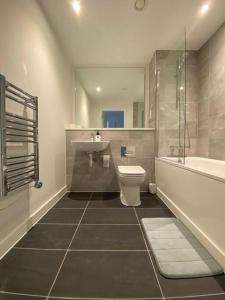 曼彻斯特Luxury 2 Bedroom Apartment in the heart of Manchester的浴室配有盥洗盆、卫生间和浴缸。