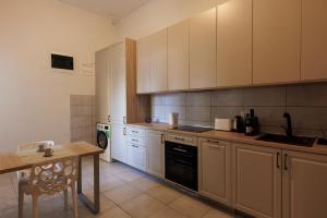 蒂米什瓦拉Victoriei Square Apartment的厨房配有白色橱柜和木桌