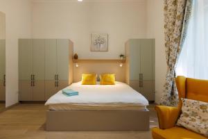 蒂米什瓦拉Victoriei Square Apartment的一间卧室配有一张带黄色枕头和椅子的床