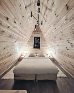 布朗Zibran Cabane的卧室配有一张木墙内的大床