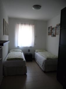 滕诺Appartamento Mora的带窗户的客房内的两张床