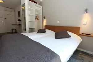斯特拉斯堡德利酒店的一间卧室配有两张带白色床单的床