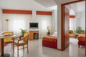 利维松多里5Miglia Hotel & Spa的酒店客房带一张床、一张桌子和椅子
