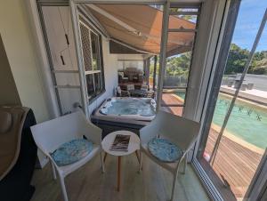 麦夸里港Luxury oasis resort Pet friendly apartment with private pool and spa的客房设有游泳池、两把椅子和一张桌子