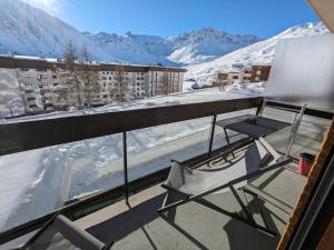 蒂涅Appartement au lac ski aux pieds的阳台配有椅子,被雪覆盖的山脉
