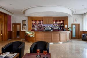 利维松多里5Miglia Hotel & Spa的餐厅内的酒吧配有两把椅子和一张桌子