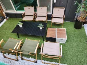 水原市Suwon station City House的一组椅子和一张桌子放在草坪上