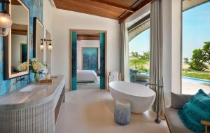 ḨanakThe St. Regis Red Sea Resort的一间带浴缸和水槽的浴室以及一间卧室