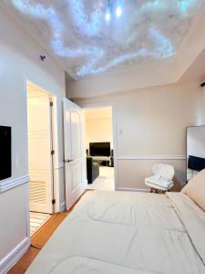 马尼拉Affordable Staycation Airbnb BGC的一间卧室设有一张床,天花板上配有电视。