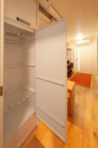 萨翁林纳Saimaan Kodikas A3的客房内的白色冰箱,门打开