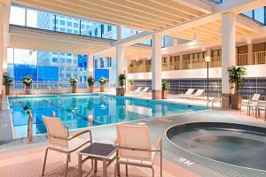 温尼伯三角洲温尼伯酒店的一座带椅子的酒店游泳池,一座建筑