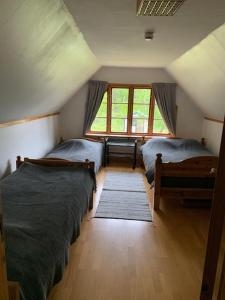LöderupSandhammaren ,skåne的阁楼卧室设有两张床和窗户。